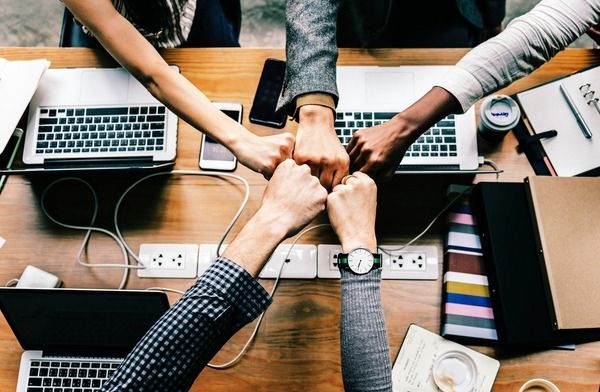 A Group Fist-Bump After A Productive Team Meeting.